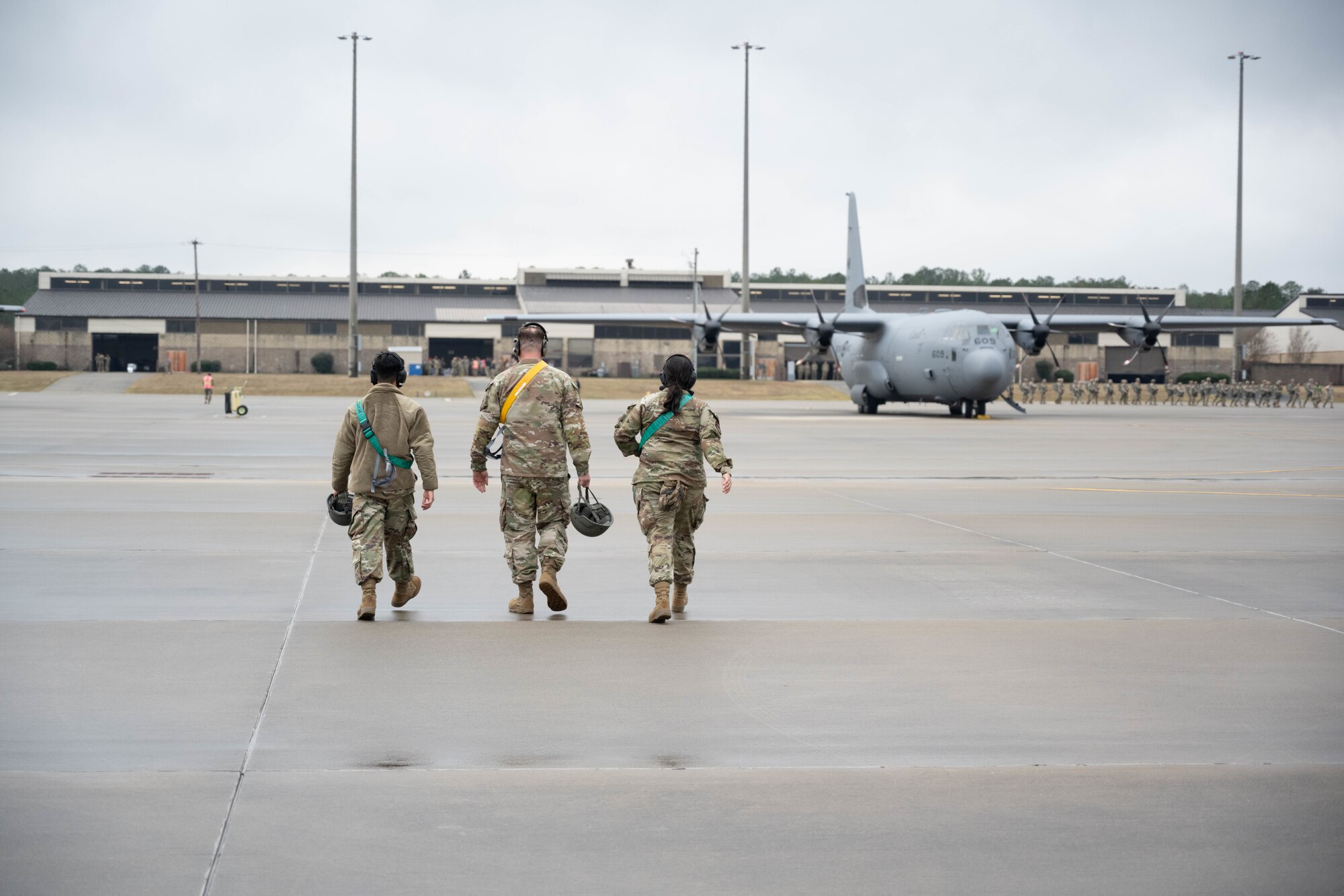 Three Airmen walk back to a passenger terminal.