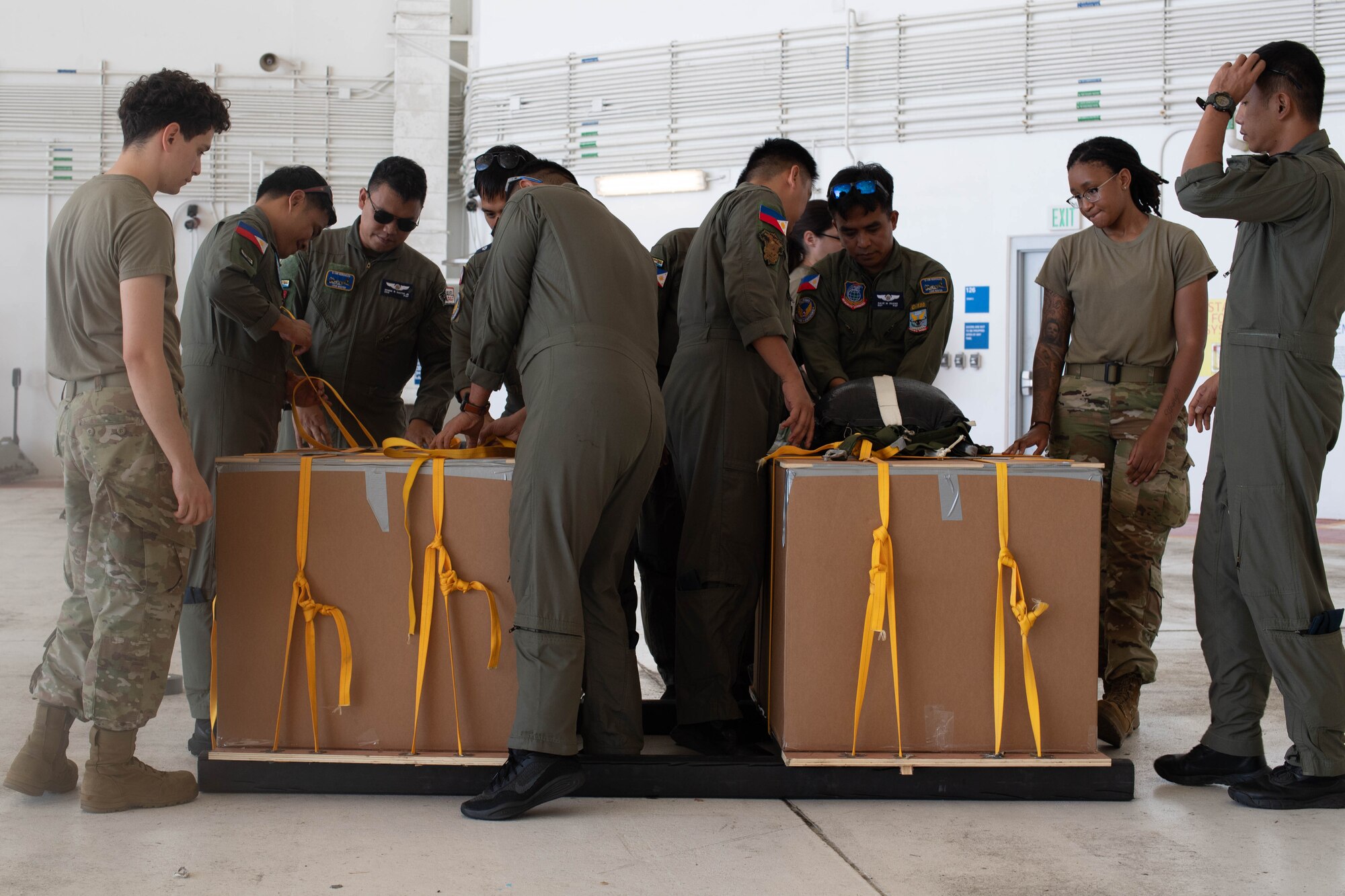 A group of people work to rig a box.