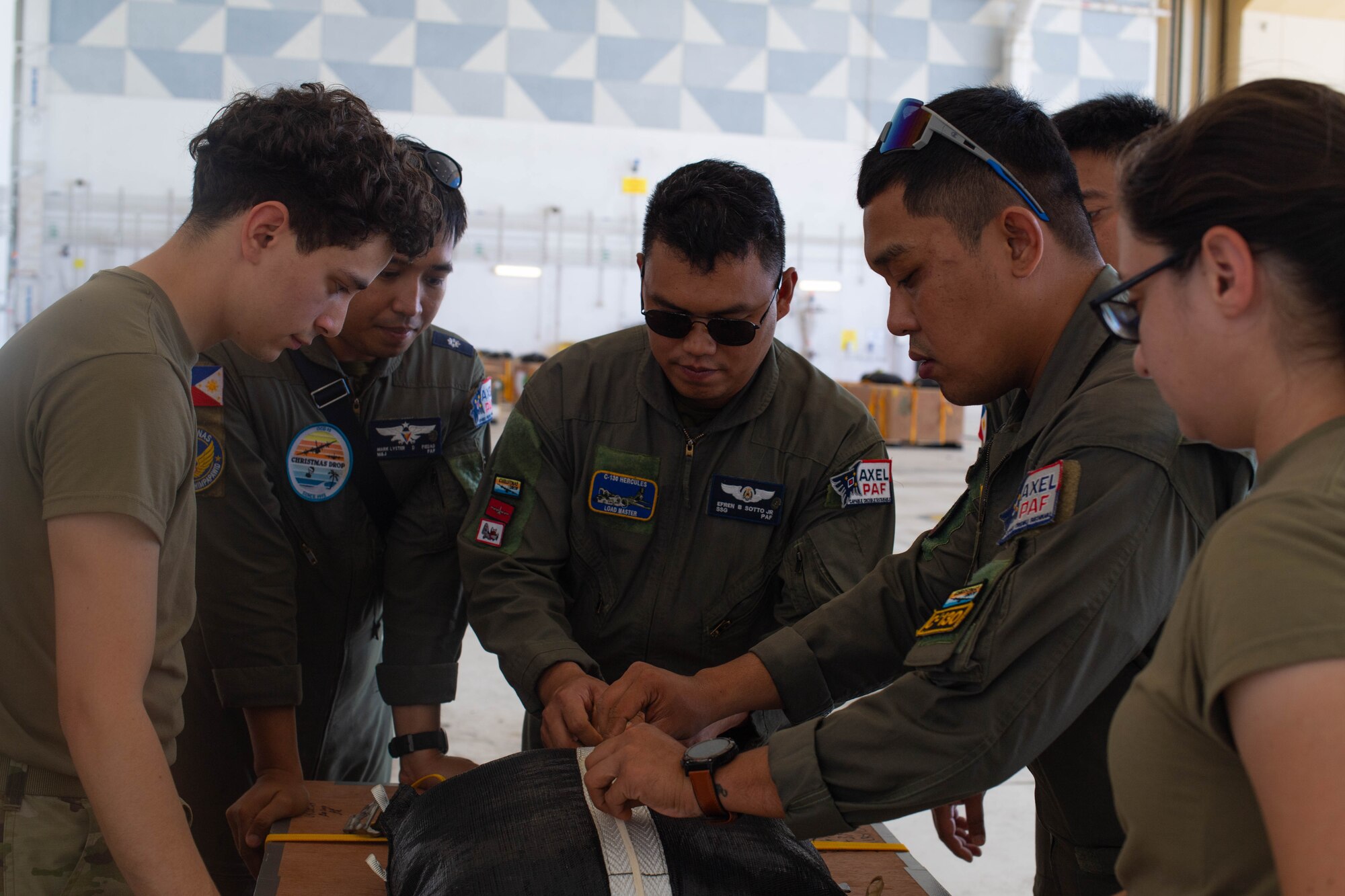 A group of people rig a parachute.