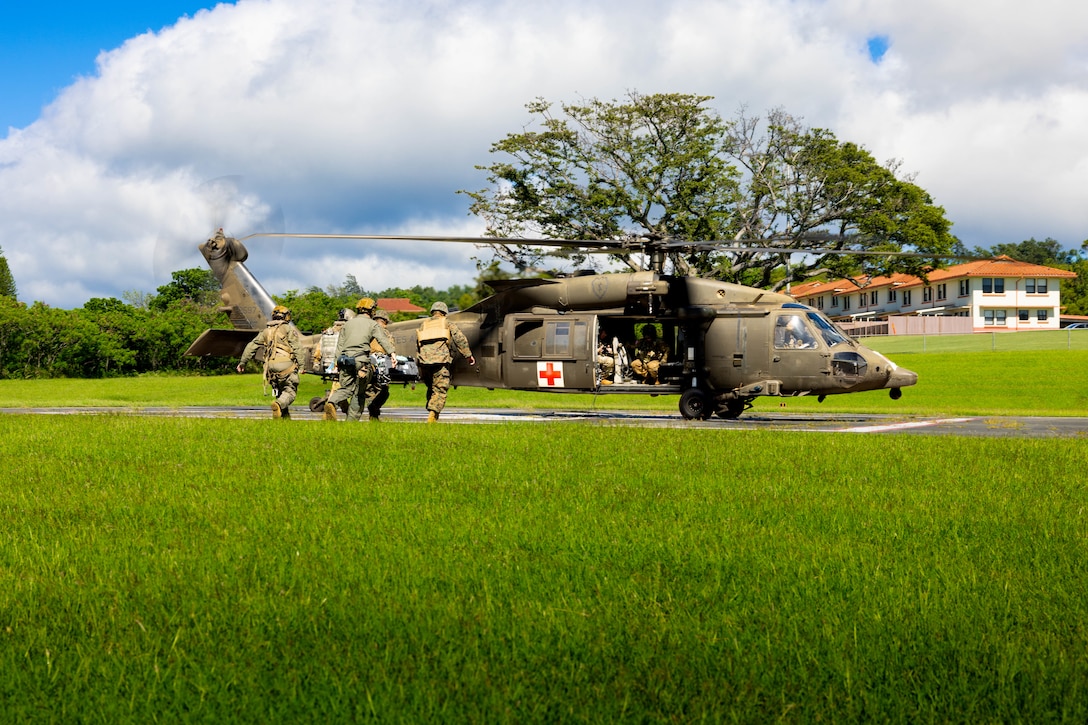 U.S. Navy corpsmen with Bravo Surgical Company, 3d Medical Battalion, load a simulated casualty onto a U.S. Army UH-60Q Black Hawk during joint casualty evacuation (CASEVAC) and hoist training, Joint Base Pearl Harbor-Hickam, Hawaii, Nov. 20, 2024. 3d Med Bn provided health service support in joint operations and increased interoperability with U.S. Army MEDEVAC platforms and transportation companies. (U.S. Marine Corps photo by Lance Cpl. Marcos AlbertoRocha)