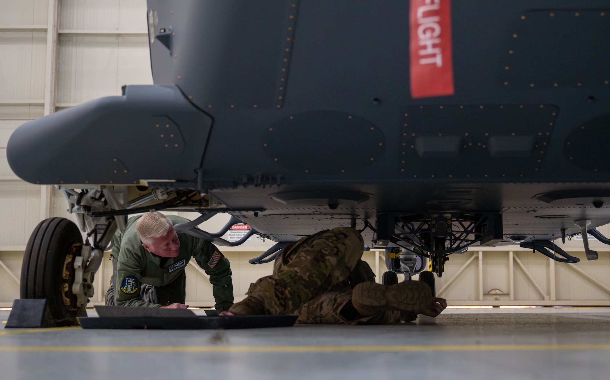 two people look under an aircraft