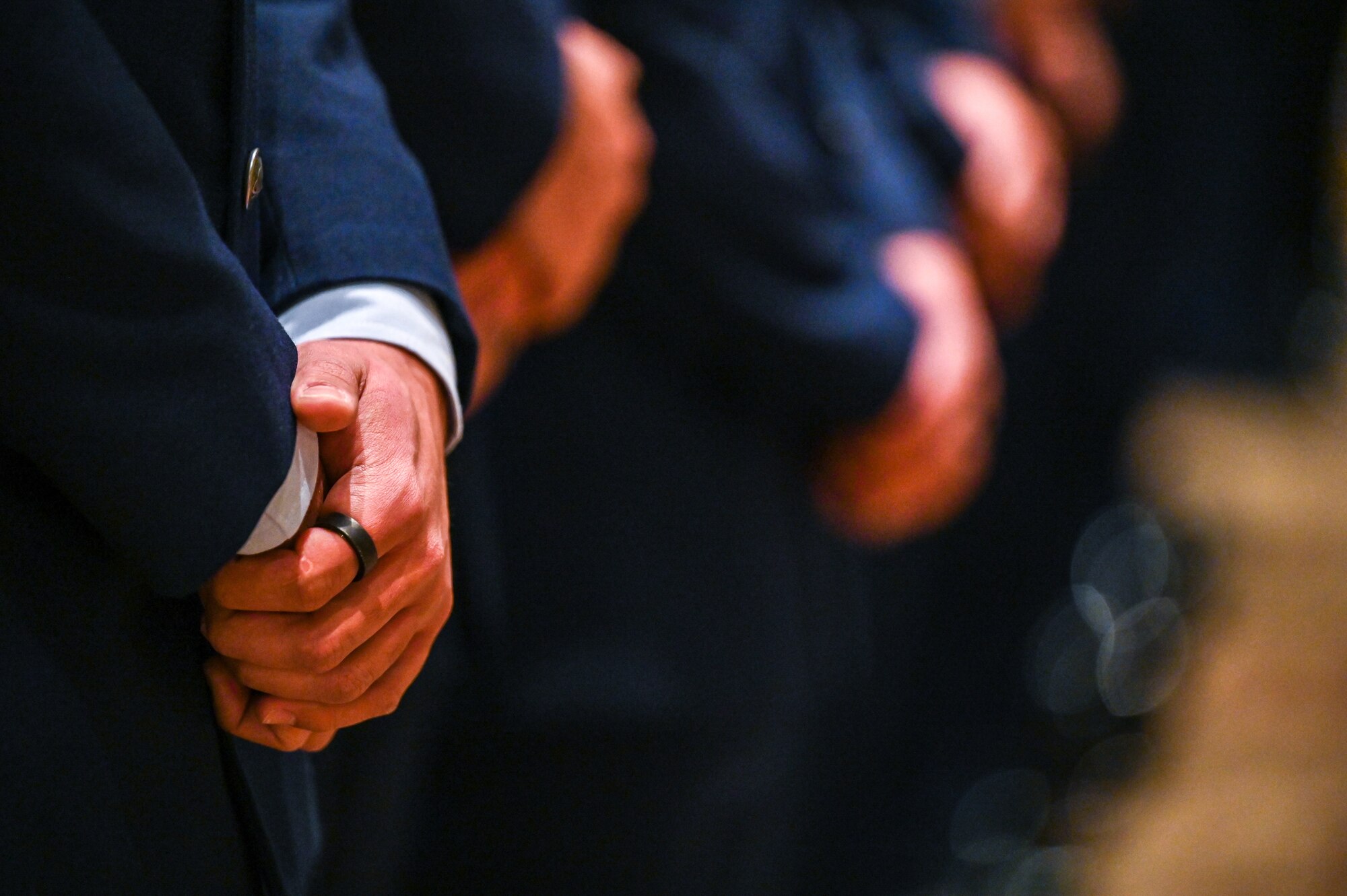air force members hands clasped during invocation