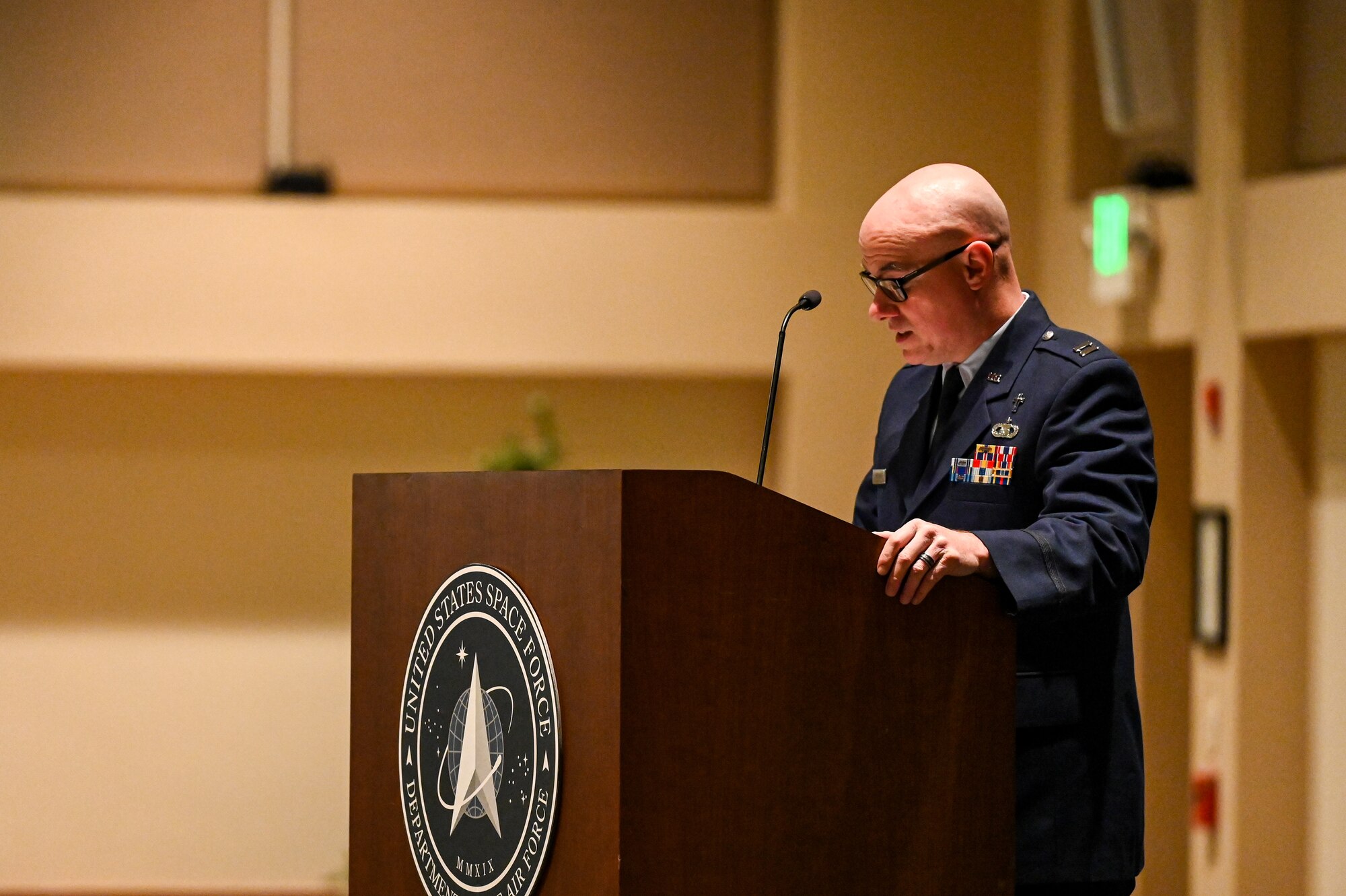 air force chaplain leads invocation at podium