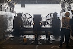 A truck is unloaded from an LCAC onto a larger vessel.