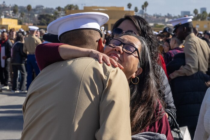 A new U.S. Marine with Charlie Company, 1st Recruit Training Battalion, is greeted by his guest following his graduation ceremony at Marine Corps Recruit Depot San Diego, California, Dec. 13, 2024. Graduation took place at the completion of the 13-week transformation, which included training for drill, marksmanship, basic combat skills, and Marine Corps customs and traditions. (U.S. Marine Corps photo by Lance Cpl. Jacob B. Hutchinson)