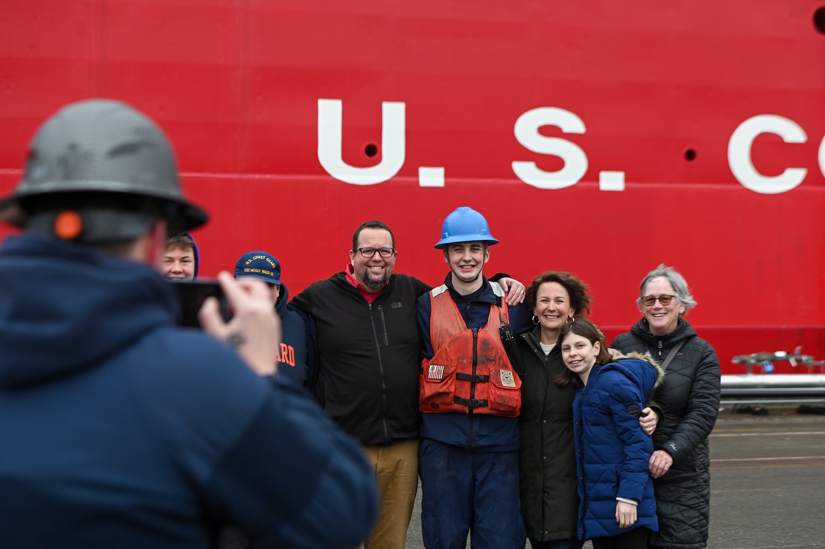 A member of the Coast Guard Cutter Healy (WAGB 20) embraces his family member on the pier at Base Seattle after a multi-month deployment, Dec. 12, 2024. The Healy is one of two icebreakers stationed in Seattle and is the only military ship dedicated to conducting research in the Arctic. (U.S. Coast Guard photo by Petty Officer 3rd Class Annika Hirschler)