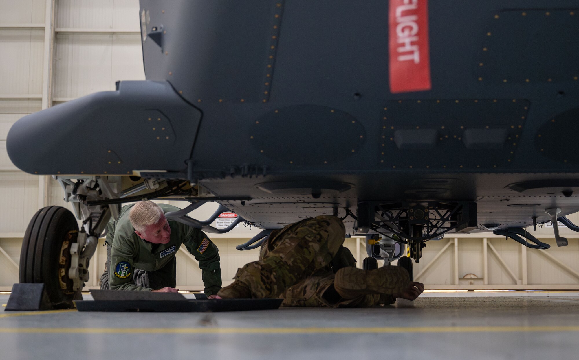 two people look under an aircraft