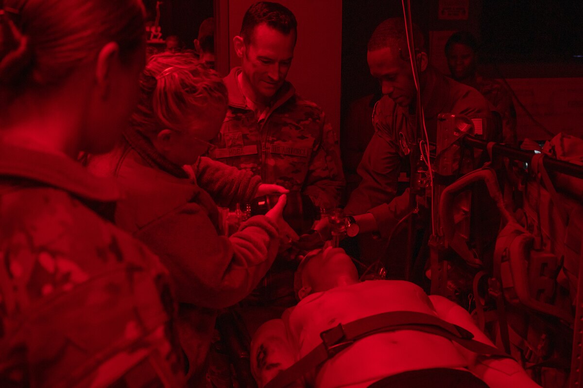 Four people work on a medical dummy during an exercise