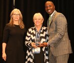 Denise Myers (center), a Center for Information Warfare Training instructional management program manager and systems specialist, is presented the Council on Occupational Education’s first Liaison Hall of Fame Award during the organization’s 2024 annual meeting Nov. 14 in Atlanta. Myers was honored for her work as CIWT’s accreditation liaison official. (Contributed photo)