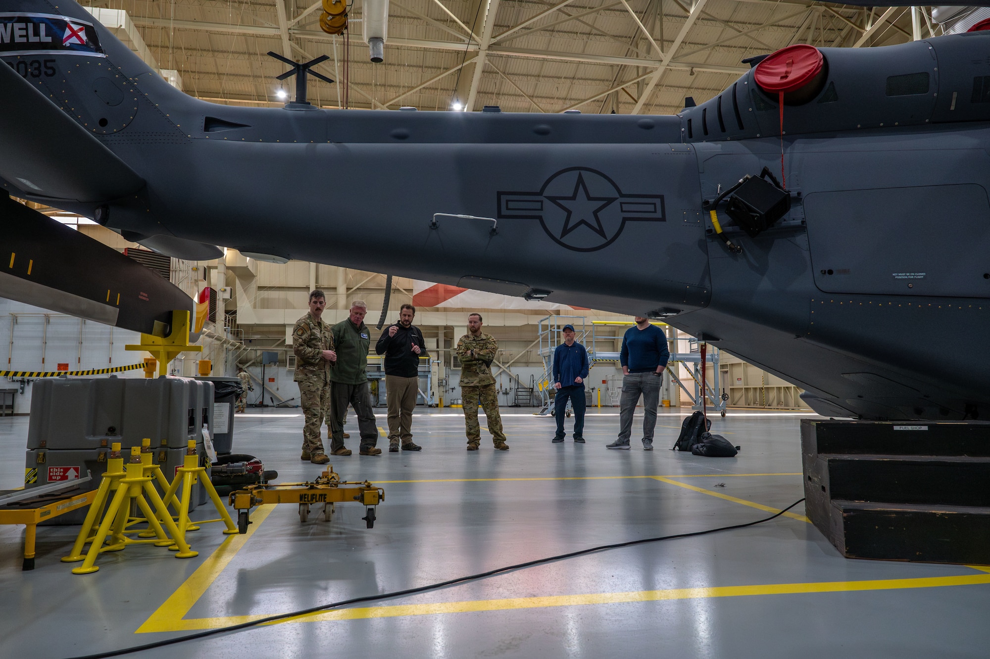 people stand around a helicopter training device
