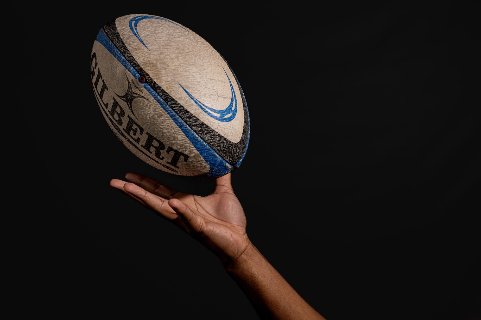 U.S. Air Force 2nd Lt. Eric Wills, 325th Logistics Readiness Squadron traffic management operations officer in charge, tosses a rugby ball up for a portrait photo