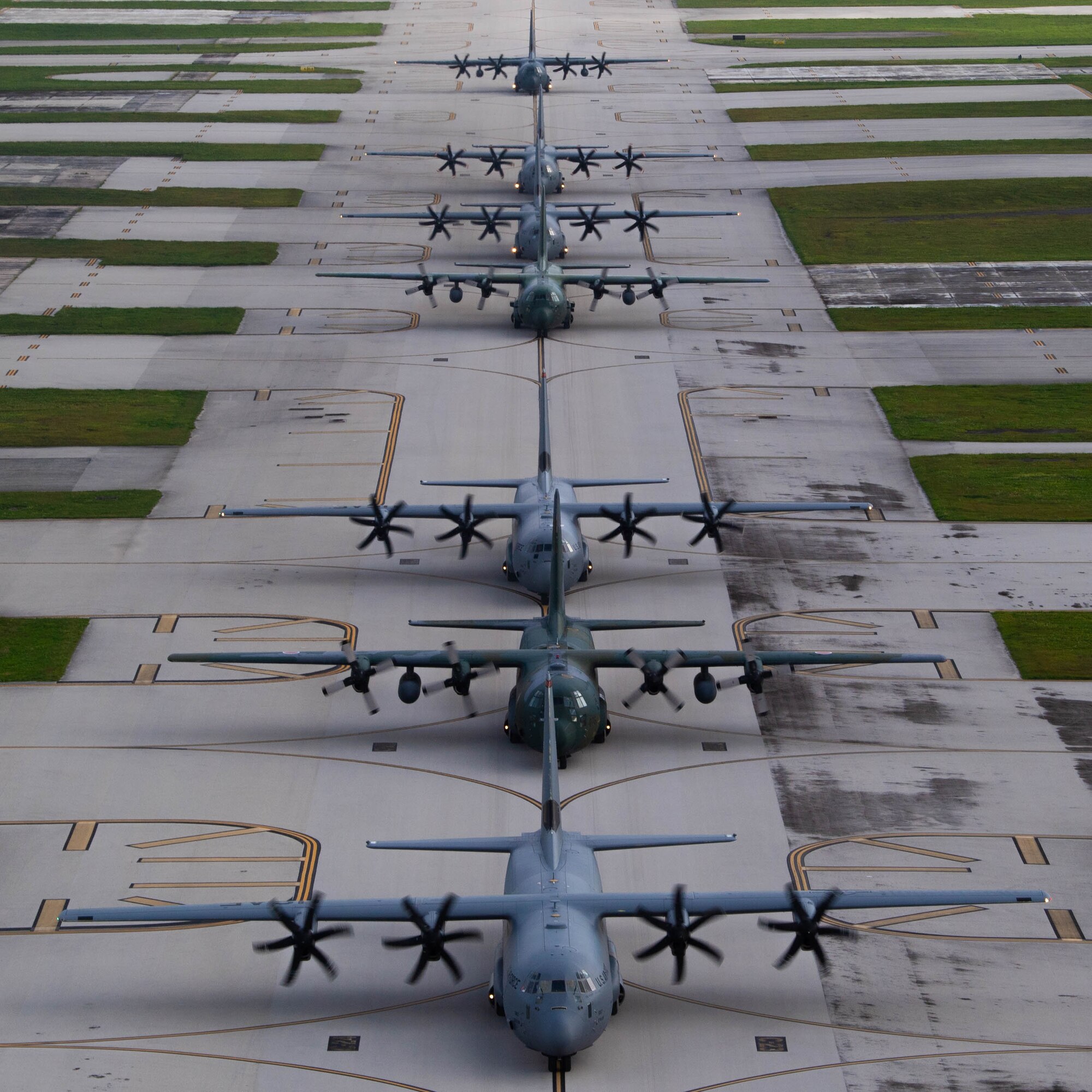 Seven aircraft drive on a flight line.