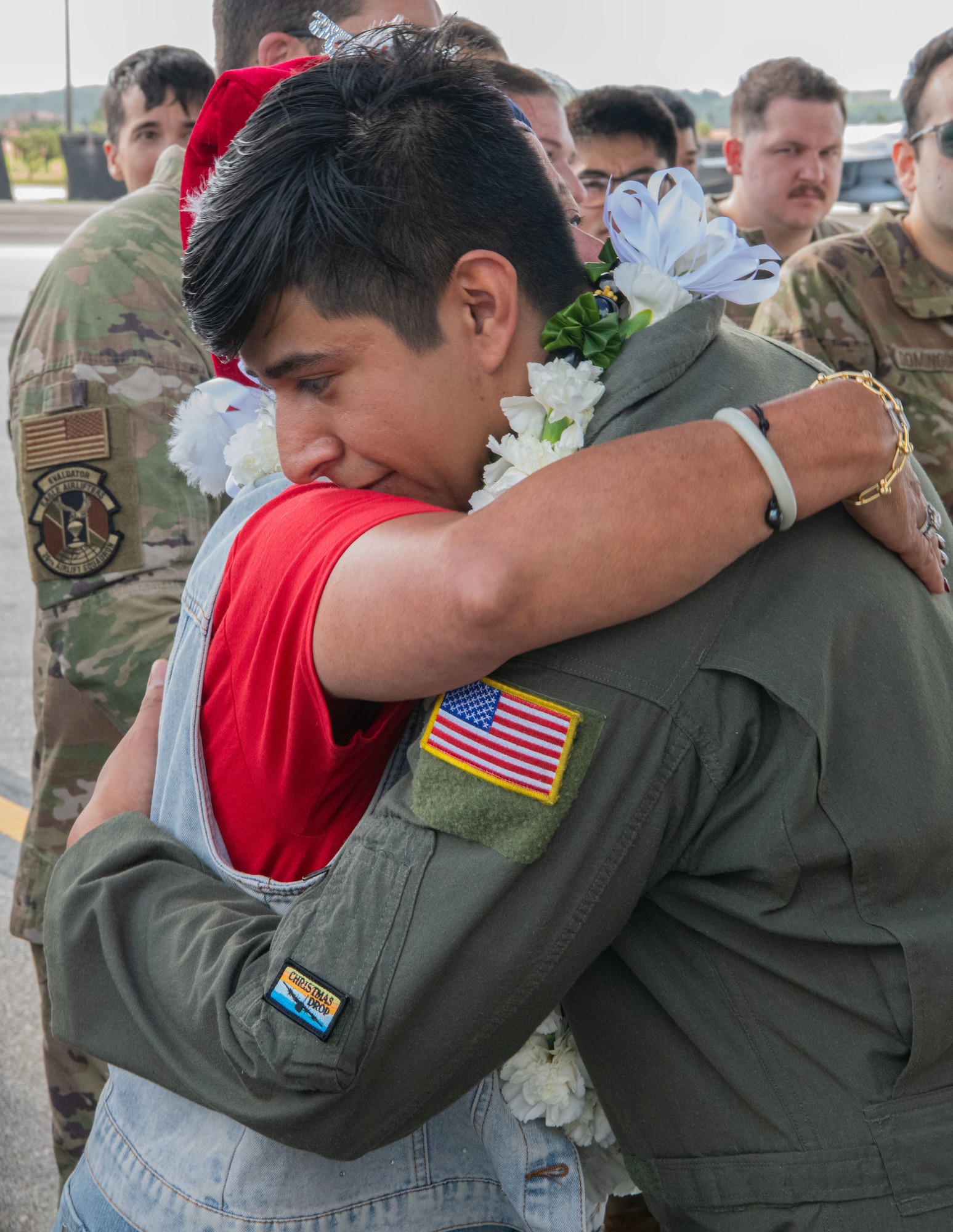 Airmen, family members, and international partners gathered at Andersen Air Force Base, Guam, December 12, 2024, to honor U.S. Air Force Senior Airman Jeremy Jutba-Hake, who passed away in 2015 while supporting Operation Christmas Drop. A commemorative aid bundle signed by attendees was later delivered to remote Pacific islands as part of the annual humanitarian mission. (U.S. Air Force photo by [Photographer's Name])