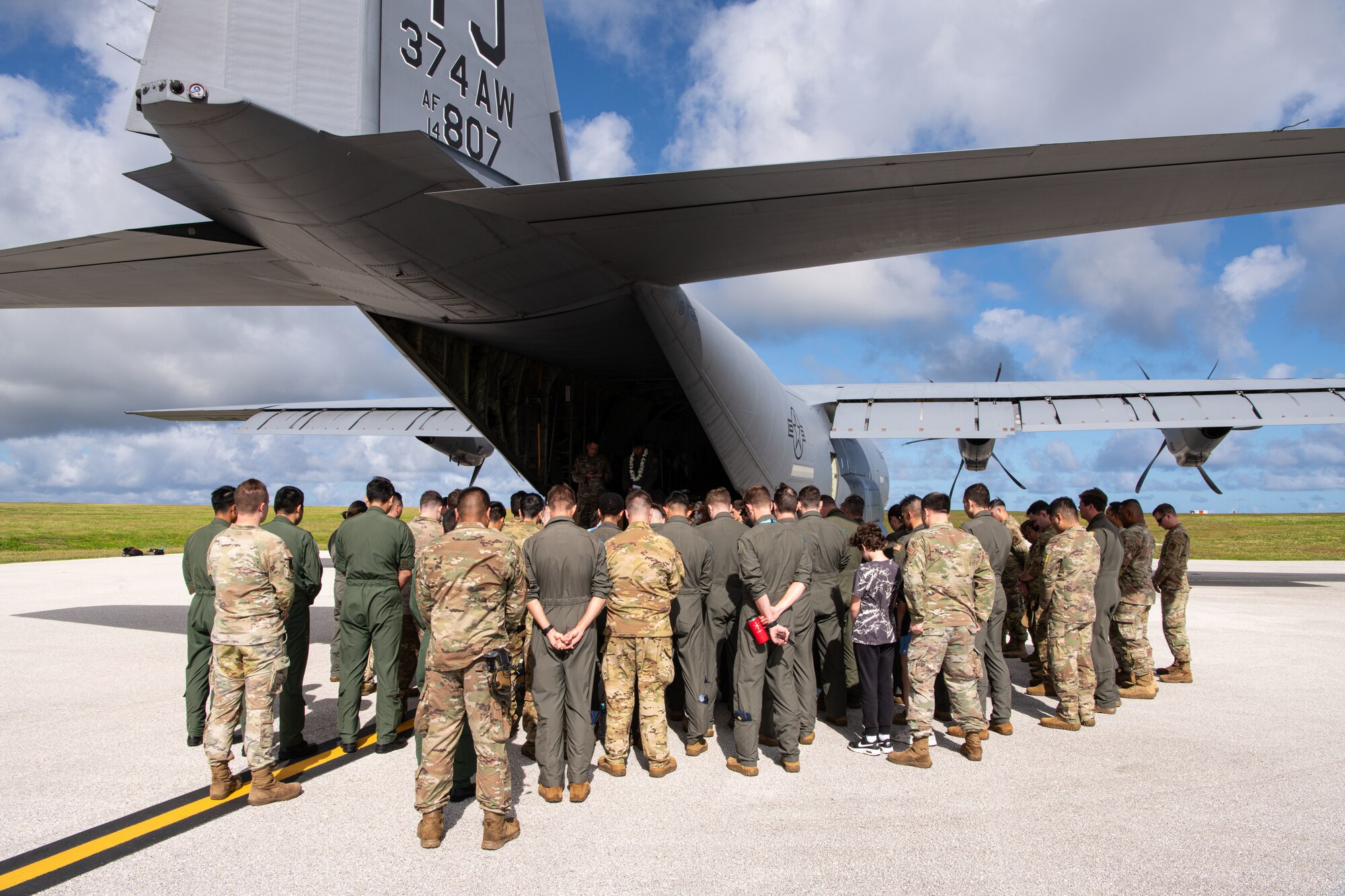 Airmen, family members, and international partners gathered at Andersen Air Force Base, Guam, December 12, 2024, to honor U.S. Air Force Senior Airman Jeremy Jutba-Hake, who passed away in 2015 while supporting Operation Christmas Drop. A commemorative aid bundle signed by attendees was later delivered to remote Pacific islands as part of the annual humanitarian mission. (U.S. Air Force photo by [Photographer's Name])
