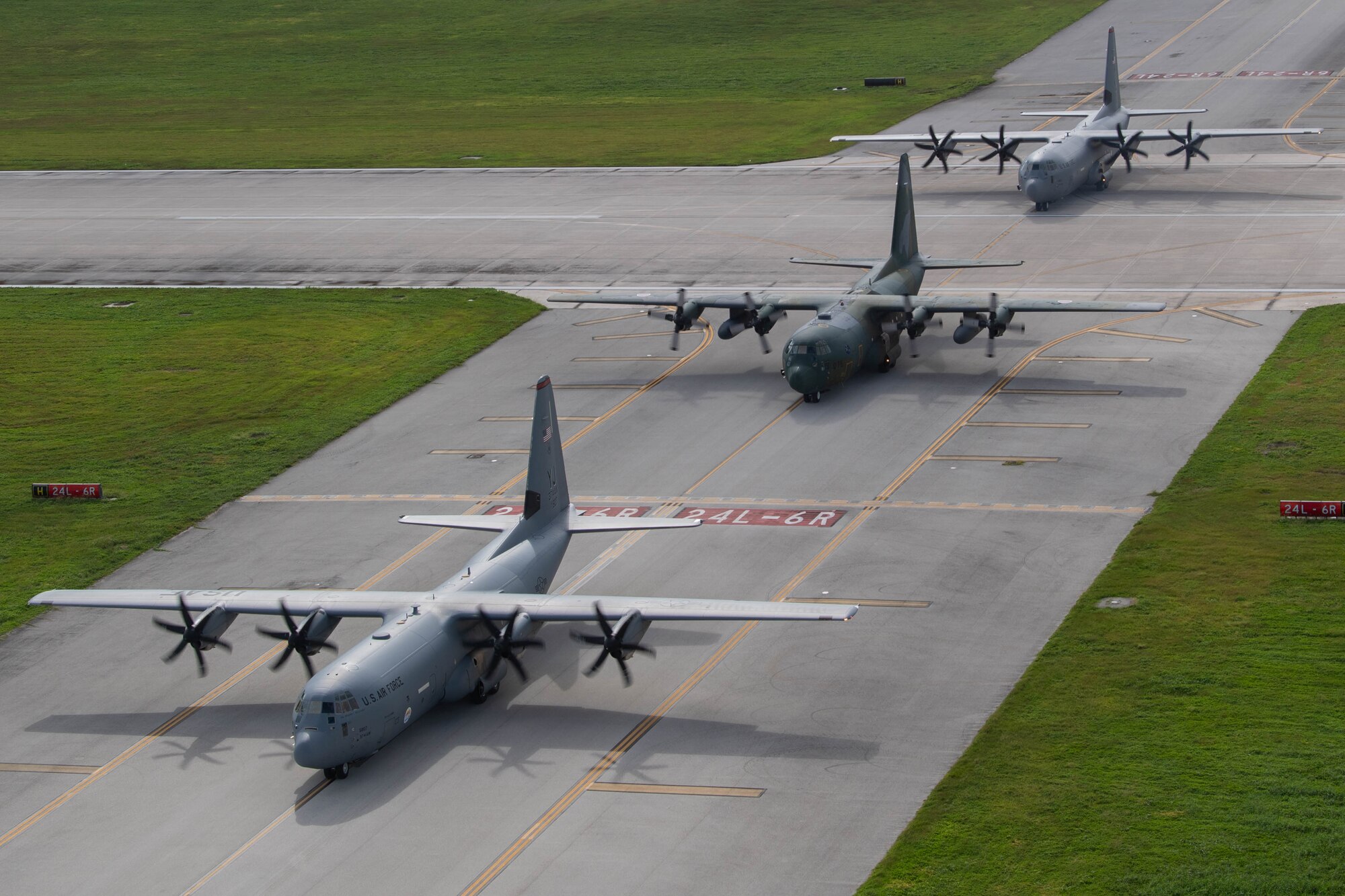Three aircraft drive on a flight line in formation.