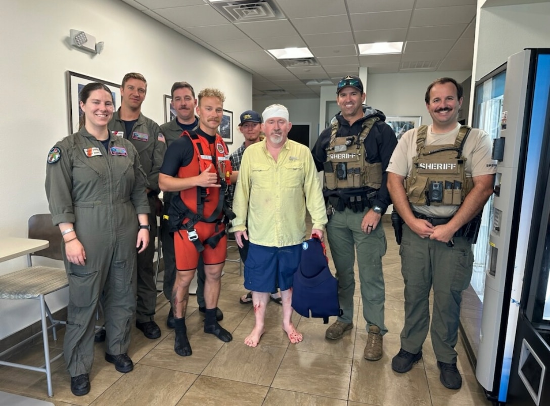 Crew members from Coast Guard Air Station Miami and Martin County Sheriff's Office pose with a man who was rescued from a jetty in the vicinity of St Lucie Inlet, Dec. 15, 2024. The aircrew brought the man to Stuart Airport with no medical concerns. (U.S. Coast Guard photo)