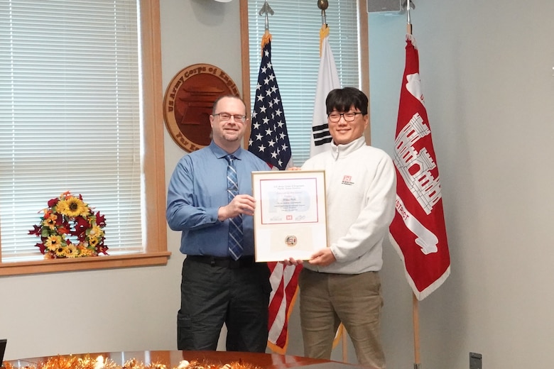 Sang Na, Civil Engineer, U.S. Army Corps of Engineers – Far East District, accepts Minjae “MJ” Park’s certificate on his behalf at the USACE Leadership Development Program (ULDP) Level 3 graduation held Dec. 5, 2024, at Camp Humphreys, South Korea. Park attended virtually due to work obligations. Daniel Foltz, Deputy Chief of Programs & Project Management, USACE-FED, presents Ji with his certificate. (U.S. Army photo by Kyong Il Yo)