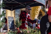 A volunteer hands out hot chocolate at the Holiday Express event at Marine Corps Recruit Depot San Diego, California, Dec. 7, 2024. The Holiday Express is an annual event held at the Depot to bring holiday cheer to Marines, civilian employees and their families with crafts, music, opportunity drawings and more. (U.S. Marine Corps photo by Cpl. Alexander O. Devereux)