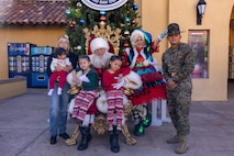 U.S. Marine Corps Staff Sgt. Andrew Aguilar, a drill instructor with India Company, 3rd Recruit Training Battalion, and his family, pose for a photo with Santa at the Holiday Express event at Marine Corps Recruit Depot San Diego, California, Dec. 7, 2024. The Holiday Express is an annual event held at the Depot to bring holiday cheer to Marines, civilian employees and their families with crafts, music, opportunity drawings and more. (U.S. Marine Corps photo by Cpl. Alexander O. Devereux)