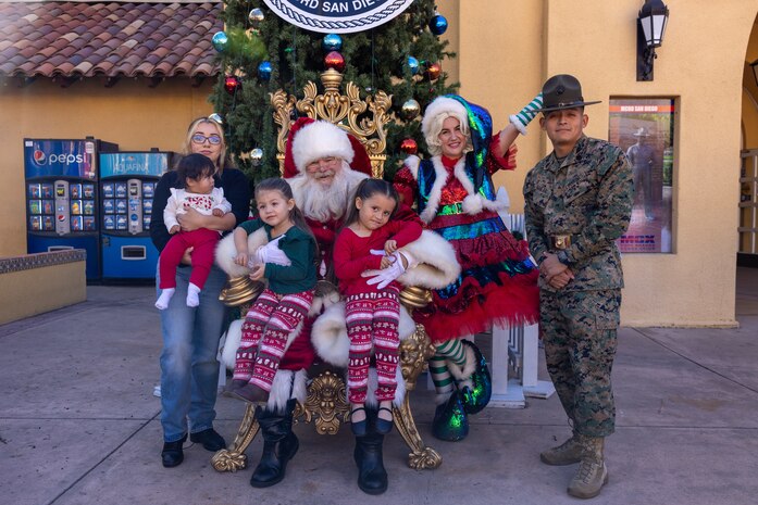 U.S. Marine Corps Staff Sgt. Andrew Aguilar, a drill instructor with India Company, 3rd Recruit Training Battalion, and his family, pose for a photo with Santa at the Holiday Express event at Marine Corps Recruit Depot San Diego, California, Dec. 7, 2024. The Holiday Express is an annual event held at the Depot to bring holiday cheer to Marines, civilian employees and their families with crafts, music, opportunity drawings and more. (U.S. Marine Corps photo by Cpl. Alexander O. Devereux)