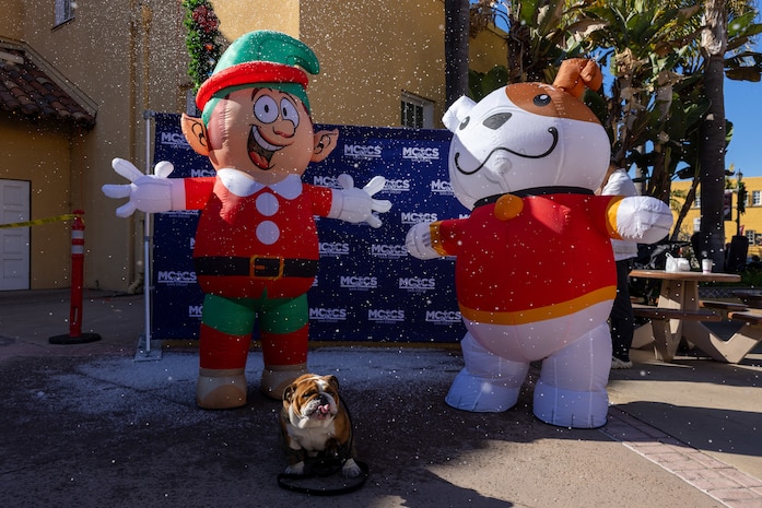 U.S. Marine Corps Lance Cpl. Bruno, the Marine Corps Recruit Depot San Diego and the Western Recruiting Region mascot, poses with some holiday characters at the Holiday Express event at Marine Corps Recruit Depot San Diego, California, Dec. 7, 2024. The Holiday Express is an annual event held at the Depot to bring holiday cheer to Marines, civilian employees and their families with crafts, music, opportunity drawings and more. (U.S. Marine Corps photo by Cpl. Alexander O. Devereux)
