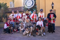 U.S. Marine Corps Cpl. Sarah Grawcock, a combat photographer and the mascot handler, and Lance Cpl. Bruno, the Marine Corps Recruit Depot San Diego and the Western Recruiting Region mascot, pose with dogs and volunteers from Independent Therapy Dogs Incorporated at the Holiday Express event at Marine Corps Recruit Depot San Diego, California, Dec. 7, 2024. The Holiday Express is an annual event held at the Depot to bring holiday cheer to Marines, civilian employees and their families with crafts, music, opportunity drawings and more. (U.S. Marine Corps photo by Cpl. Alexander O. Devereux)