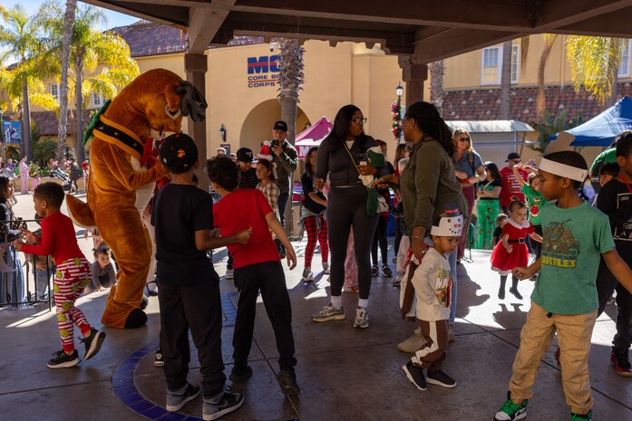 Families and volunteers dance to music provided at the Holiday Express event at Marine Corps Recruit Depot San Diego, California, Dec. 7, 2024. The Holiday Express is an annual event held at the Depot to bring holiday cheer to Marines, civilian employees and their families with crafts, music, opportunity drawings and more. (U.S. Marine Corps photo by Cpl. Alexander O. Devereux)