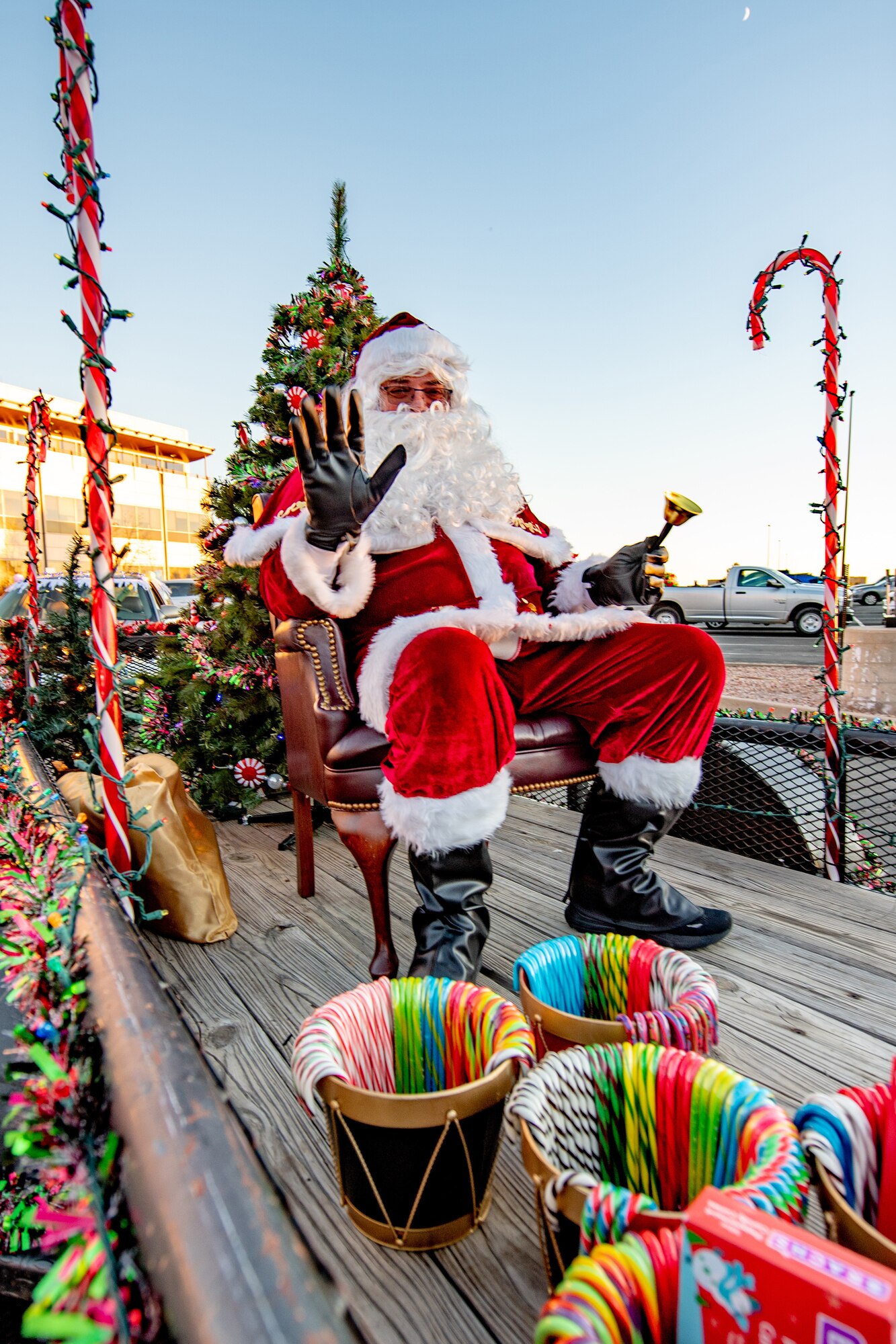 Santa Claus sits on a bed of a truck as he is being paraded around.