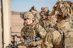 Spc. Jack Clark, 1st Battalion, 186th Infantry Regiment, Oregon Army National Guard, moves through a wall opening while Staff Sgt. Arturo Veloz supervises during urban operations training at Camp McGregor, New Mexico, Dec. 15, 2024. The unit is preparing to deploy to the Multinational Force and Observers mission in Egypt's Sinai Peninsula.