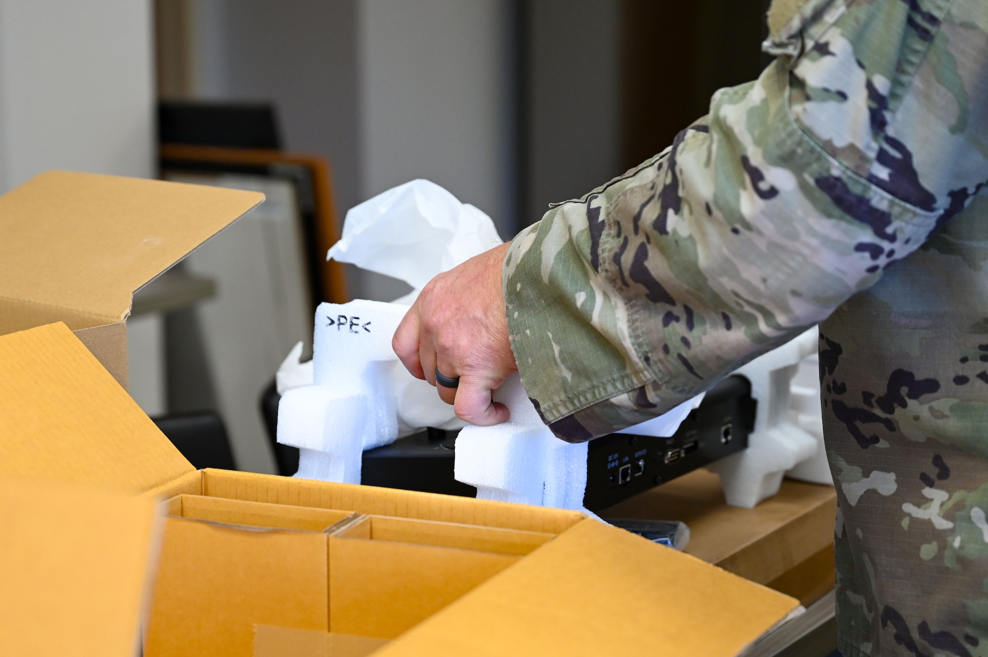 Airman unboxing a recording system.