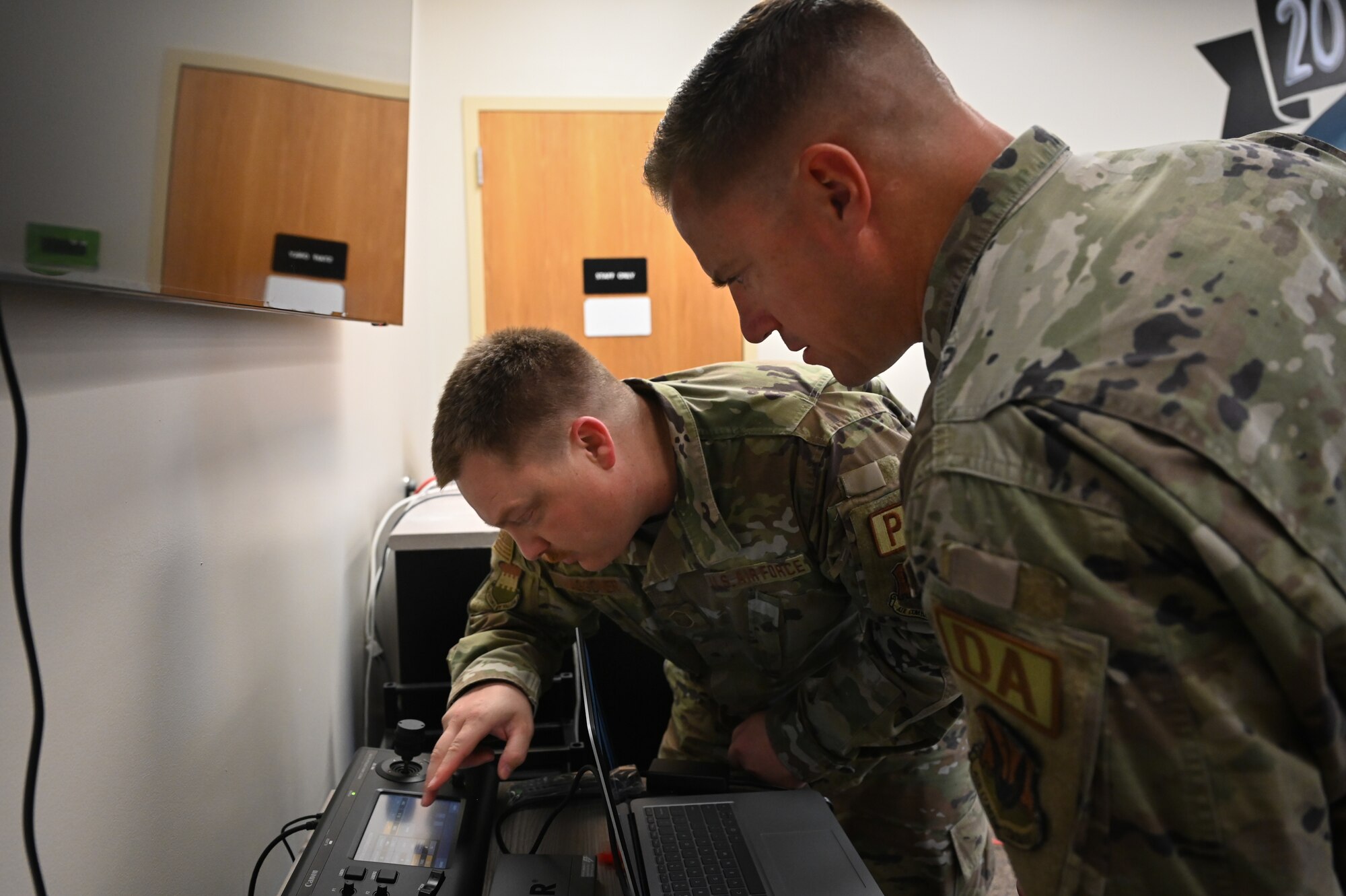 Two Airmen fixing an electrical equipment.