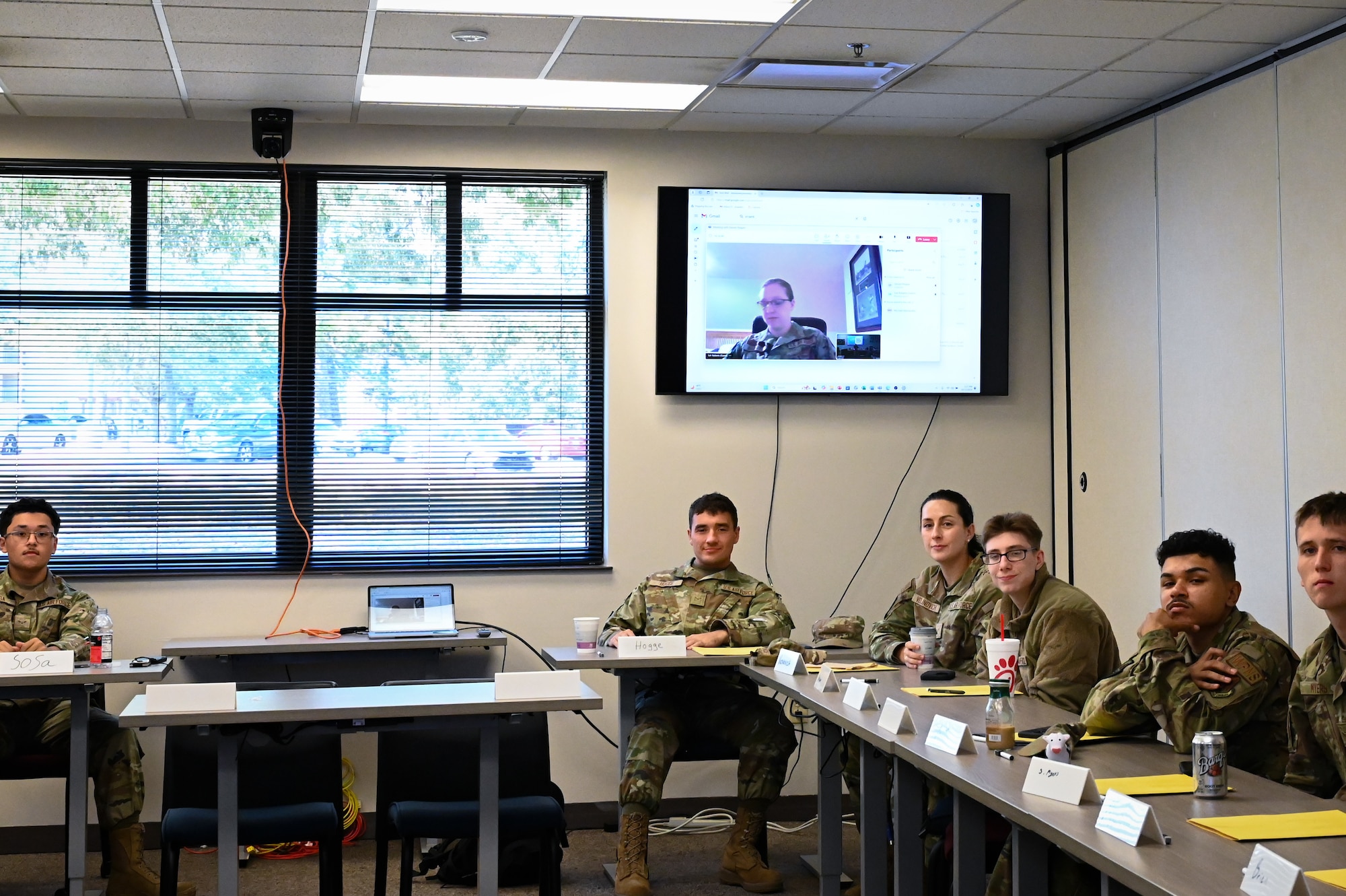 Students smiling at the camera while sitting at their desk during FTEC.