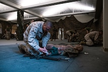 U.S. Marine Corps Recruit Cole Johnson with Bravo Company, 1st Recruit Training Battalion,  bandages a simulated wound during a combat care exam at Marine Corps Recruit Depot San Diego, California, Dec. 11, 2024. Following the knowledge exam, now taken on tablets in an effort to modernize the Marine Corps, recruits are evaluated on tactical combat casualty care, and how to disassemble and reassemble their M16A4 service rifles as taught throughout the duration of recruit training. Recruits have several opportunities to practice before exam one and the practical application test. (U.S. Marine Corps photo by Lance Cpl. Eric Valerio)