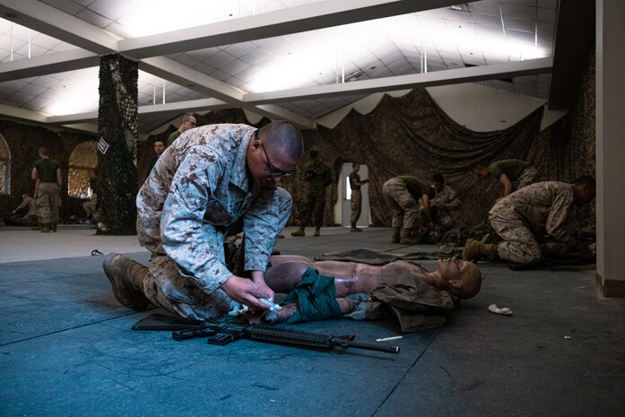 U.S. Marine Corps Recruit Cole Johnson with Bravo Company, 1st Recruit Training Battalion,  bandages a simulated wound during a combat care exam at Marine Corps Recruit Depot San Diego, California, Dec. 11, 2024. Following the knowledge exam, now taken on tablets in an effort to modernize the Marine Corps, recruits are evaluated on tactical combat casualty care, and how to disassemble and reassemble their M16A4 service rifles as taught throughout the duration of recruit training. Recruits have several opportunities to practice before exam one and the practical application test. (U.S. Marine Corps photo by Lance Cpl. Eric Valerio)