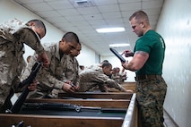 U.S. Marine Corps Sgt. Tristan Taylor, a drill instructor with Support Battalion, Recruit Training Regiment, inspects a recruits M16-A4 service rifle during a practical application exam at Marine Corps Recruit Depot San Diego, California, Dec. 11, 2024. Following the knowledge exam, now taken on tablets in an effort to modernize the Marine Corps, recruits are evaluated on tactical combat casualty care, and how to disassemble and reassemble their M16A4 service rifles as taught throughout the duration of recruit training. Recruits have several opportunities to practice before exam one and the practical application test. (U.S. Marine Corps photo by Lance Cpl. Eric Valerio)
