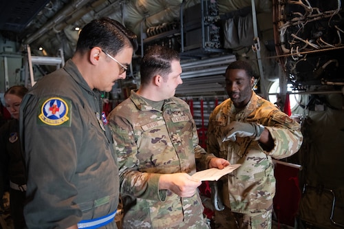 Military members talk inside of a C-130J Super Hercules.