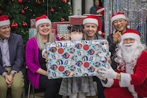 Eighth Army commanding general, Lt. Gen. Christopher LaNeve, his wife, Kimberly LaNeve, Eighth Army senior enlisted advisor, Command Sgt. Maj. Robin M. Bolmer, and Eighth Army ROK Deputy Commanding General, Brig. Gen. Sang Min Lee, take a photo with a child at Namsan-won Orphanage in Seoul, South Korea, Dec. 13, 2024.