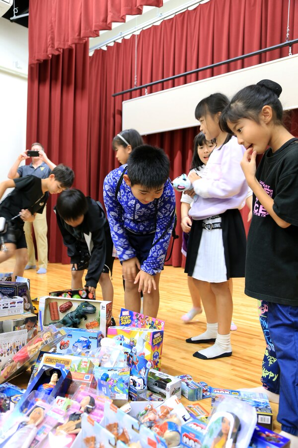 １２月１２日の夕方、宜野湾市真志喜公民館に集まった児童たちに海兵隊普天間航空基地の司令官たちがクリスマスプレゼントを贈呈しました。