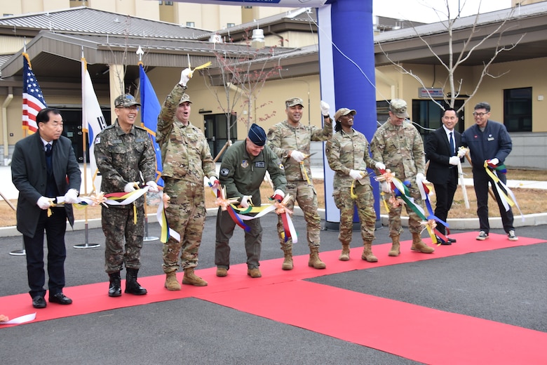 Representatives including Col. Peter Kasarskis (fourth from left), commander, 8th Fighter Wing; Col. Jeremiah Willis (third from left), commander, U.S. Army Corps of Engineers – Far East District; Col. Joshua Hawkins (center), commander, 8th Mission Support Group; and others cut the ribbon the new 39,000 square foot dining facility (DFAC) for Kunsan Air Base, South Korea, on Dec. 16, 2024. (US Army photo by Rachel Napolitan)