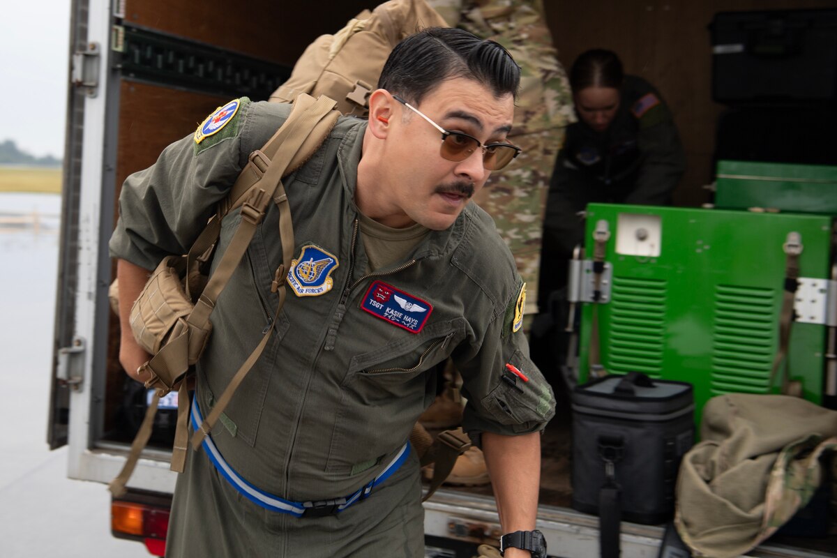 A military member carries a backpack.