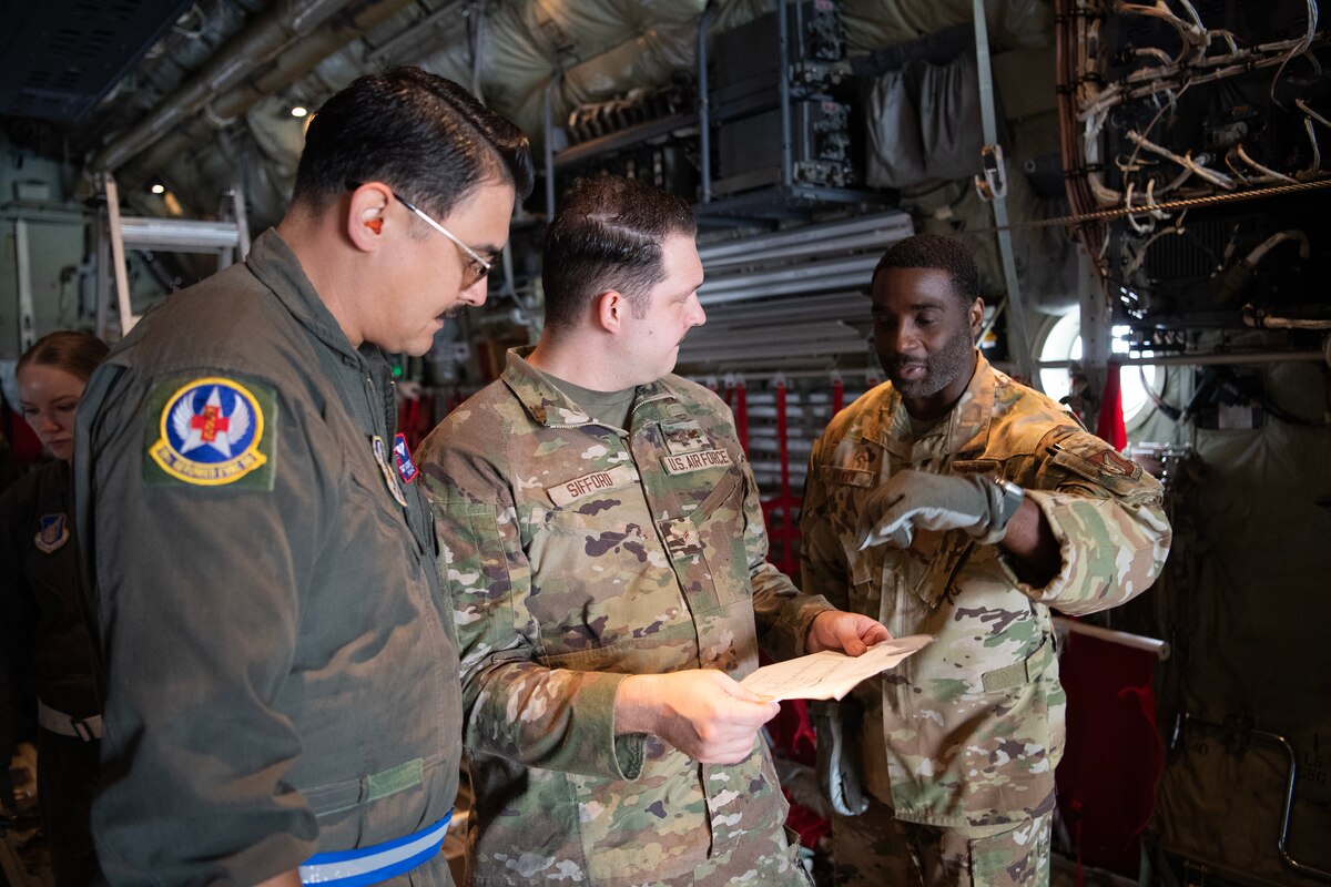 Military members talk inside of a C-130J Super Hercules.