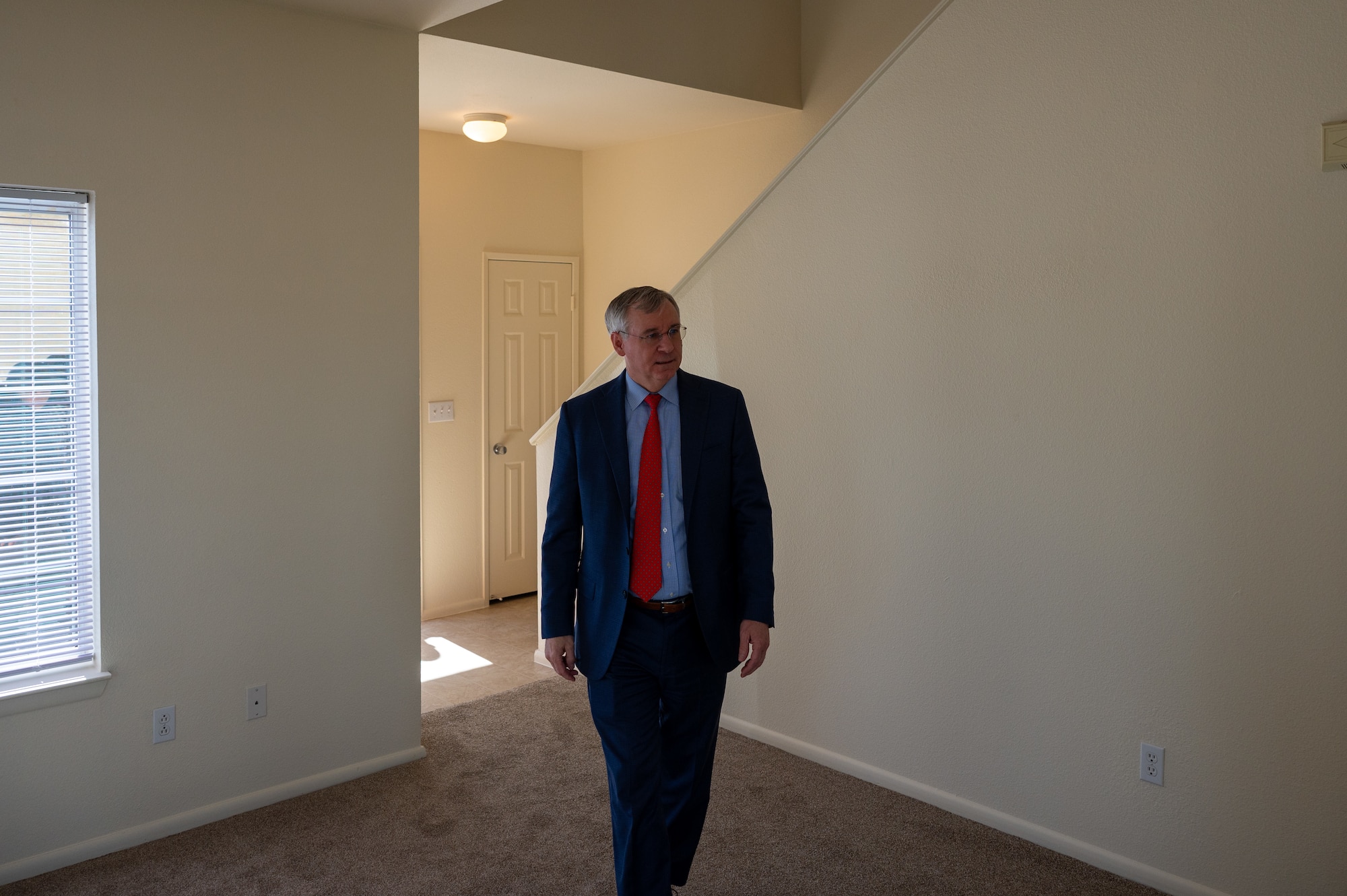 Man in suit walks through empty house