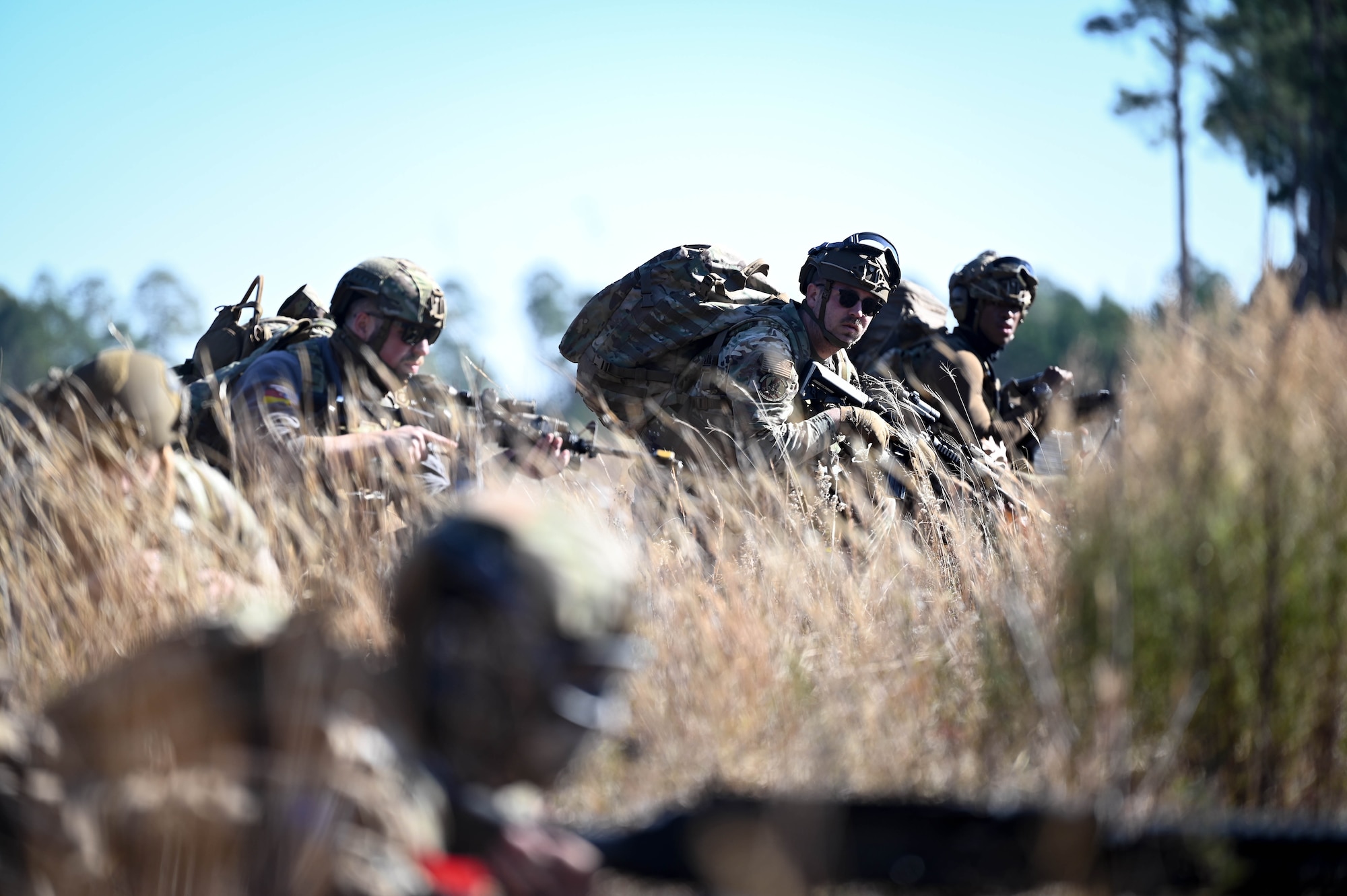 Airmen stand ready in a field.