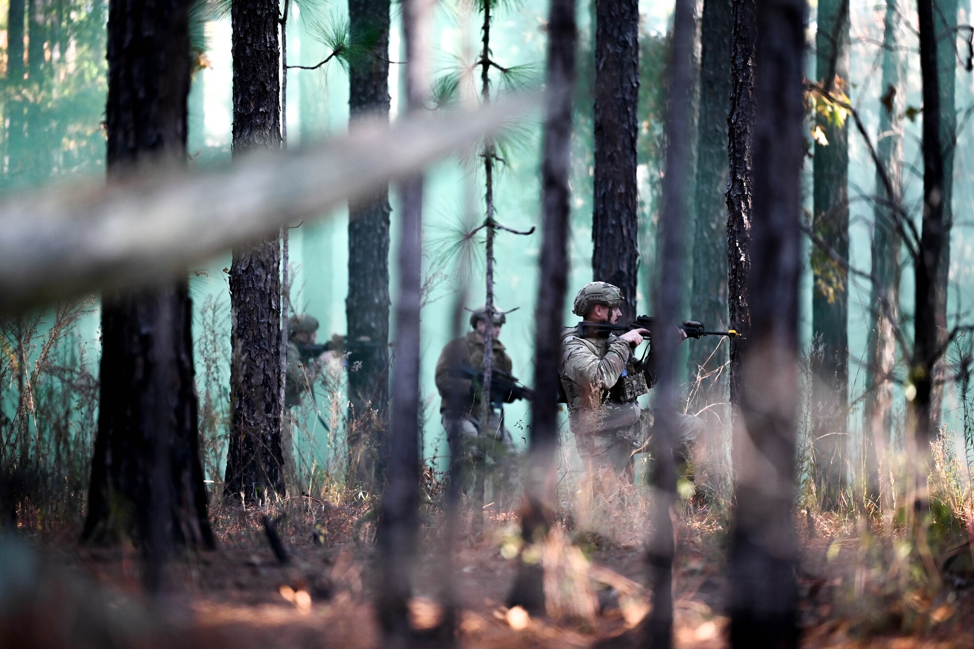 Airmen take cover behind trees.