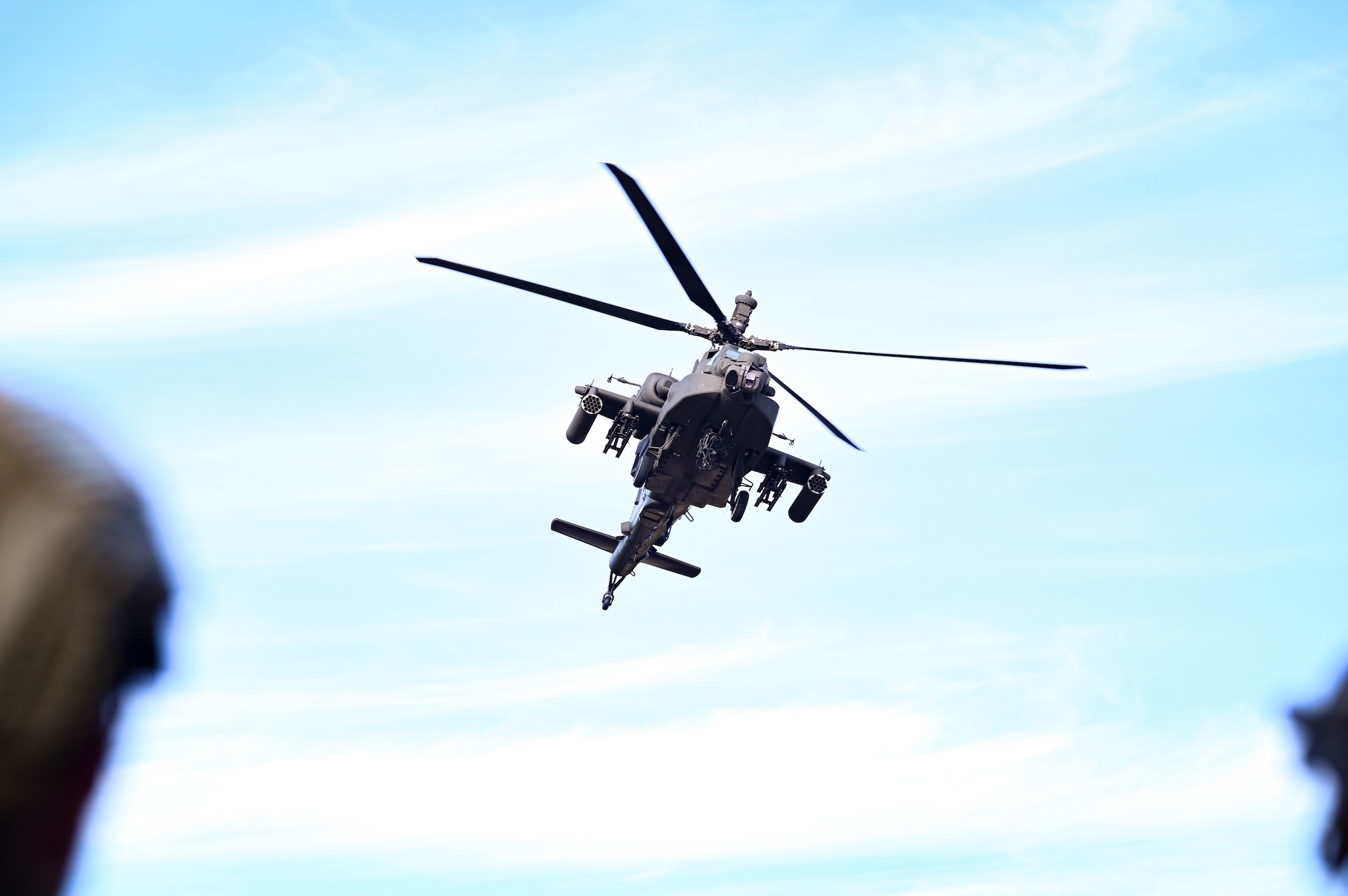 An AH-64 Apache flies overhead during an exercise.