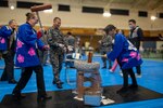 Participants of the Japan Air Self-Defense Force mochi-pounding ceremony take turns swinging mallets at Yokota Air Base, Japan, Dec. 13, 2024. The annual event emphasizes cultural exchange and strengthens the partnership between U.S. and Japanese forces. (U.S. Air Force photo by Airman 1st Class David S. Calcote)