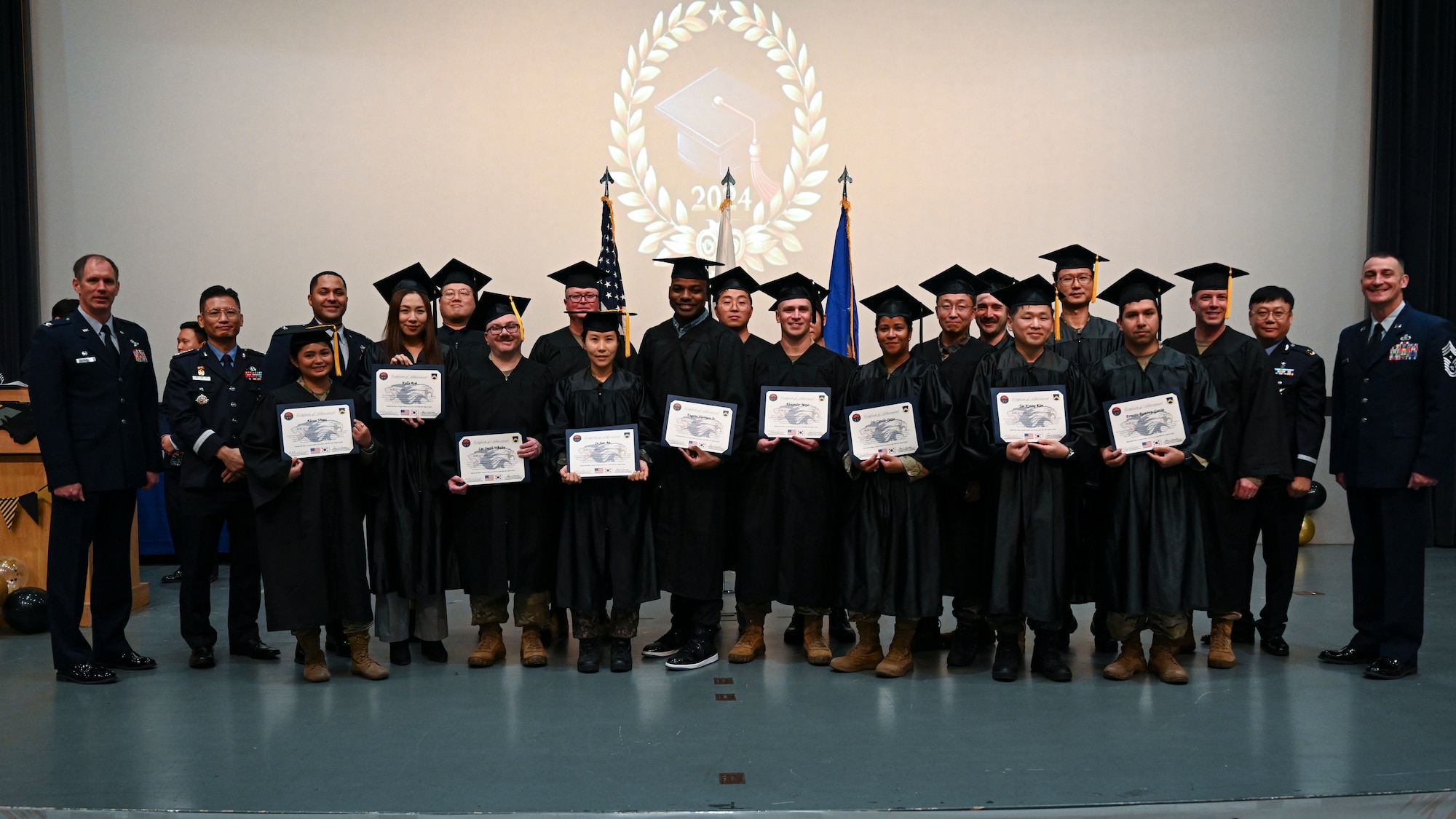 Master’s degree recipients pose with base leadership during the Joint Force Graduation ceremony at Kunsan Air Base, Republic of Korea.