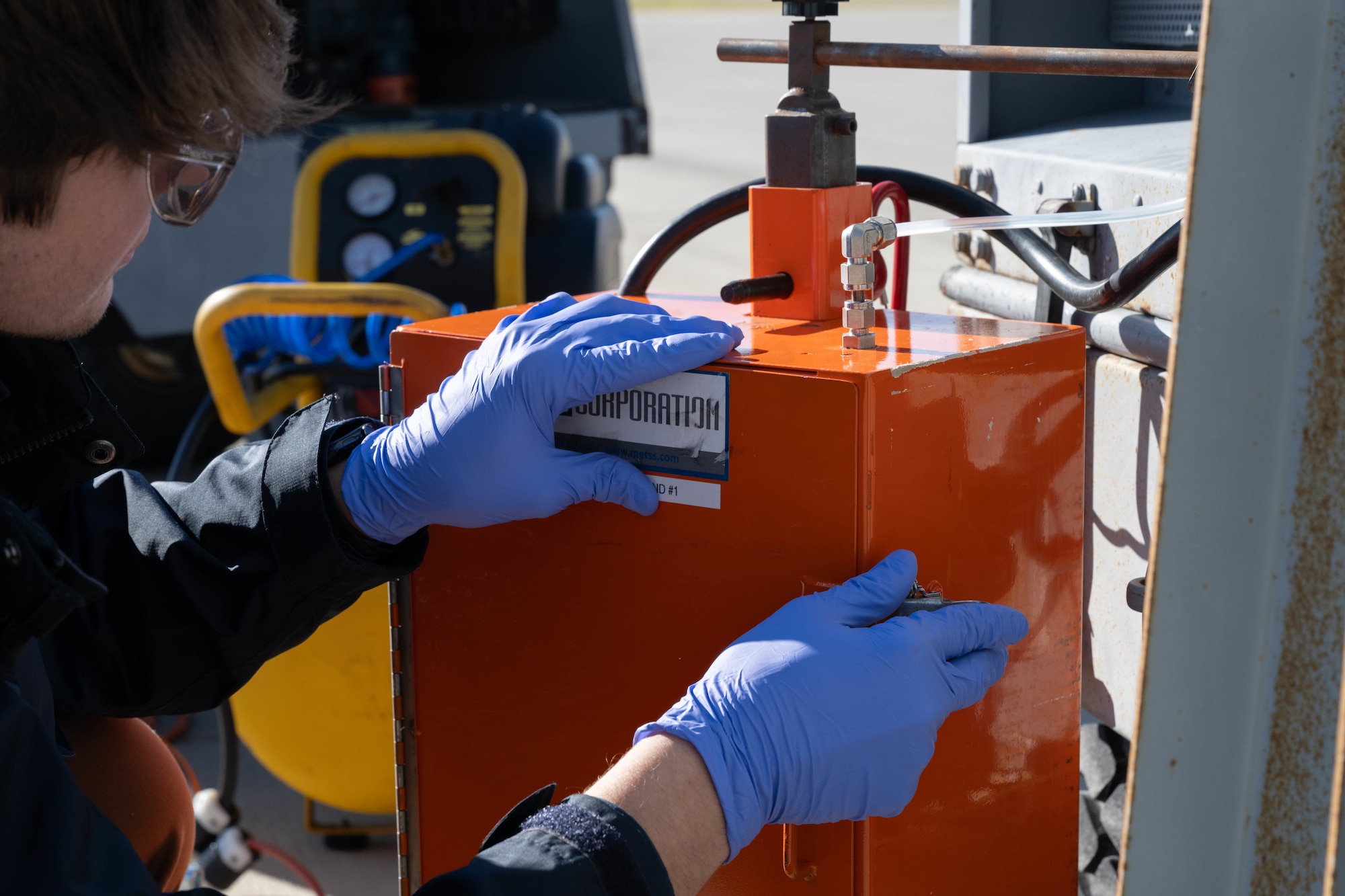 A Next Generation Aircrew Protection team member performs pre-spray checks on their orange box spray equipment at Hurlburt Field, Dec. 4, 2024.