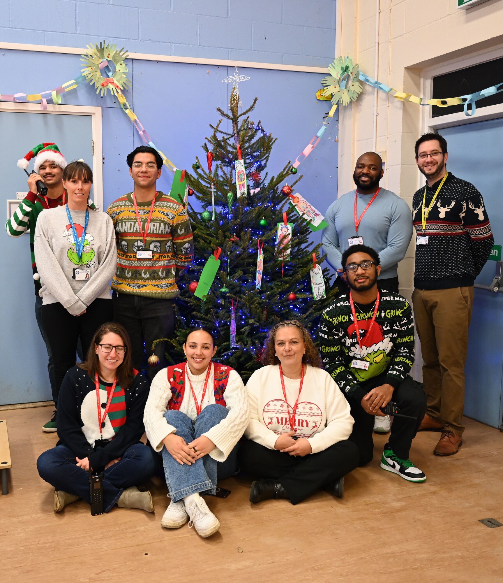 U.S. Air Force Airmen and civilians from Royal Air Force Mildenhall, England, pose for a photo with the principal and vice-principal as part of the “Radio Santa” event at Beck Row Primary Academy, Beck Row, England, Dec. 12, 2024. The 100th Communications Squadron Airmen and 100th Air Refueling Wing civilians visited the primary academy to provide young students a chance to talk to Santa and make special gift requests before the holidays. (U.S. Air Force photo by Karen Abeyasekere)