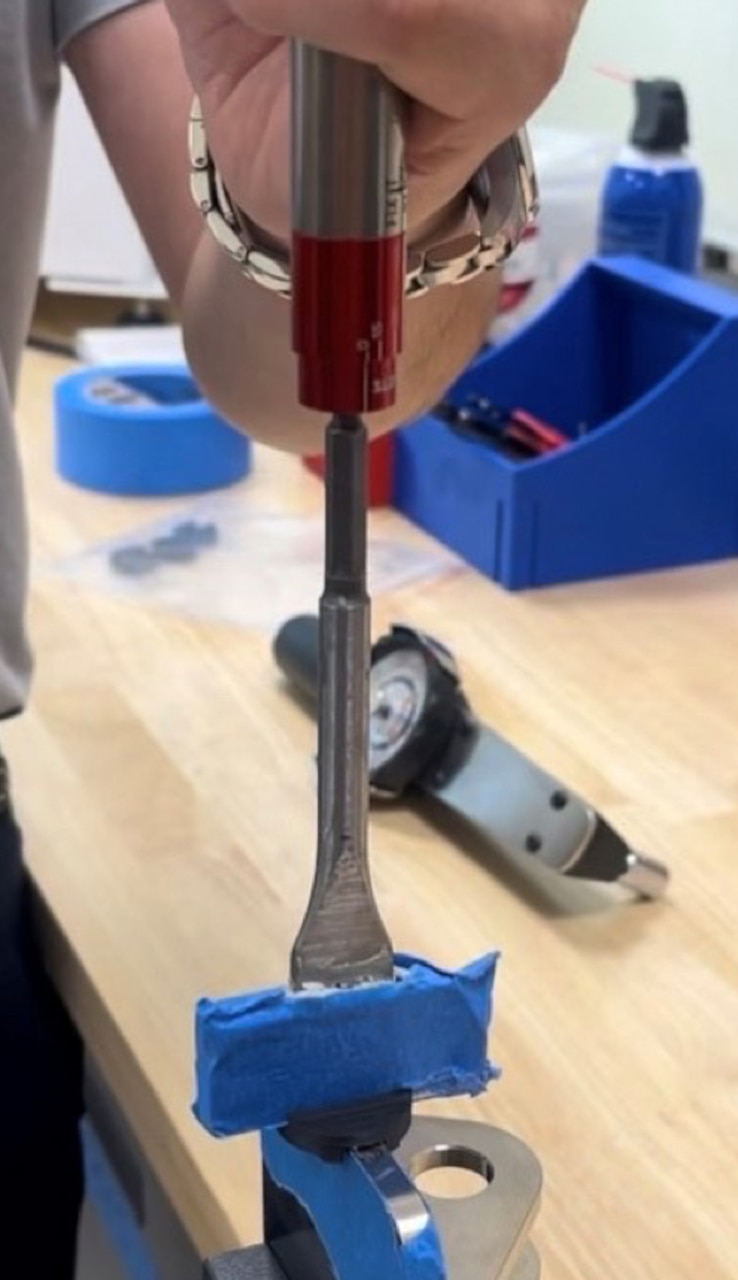 An engineer with the NAVAIR AM team uses a torque wrench to test the part's breakaway requirement.